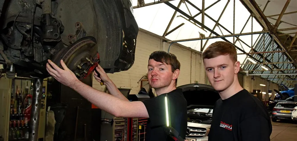 Two men working on a black car