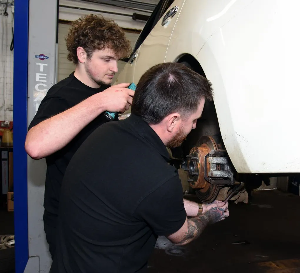 Two men working on a white car