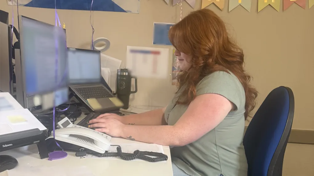 Participant sitting at desktop computer typing on keyboard