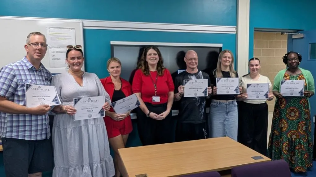 Group of graduates holding certificates.