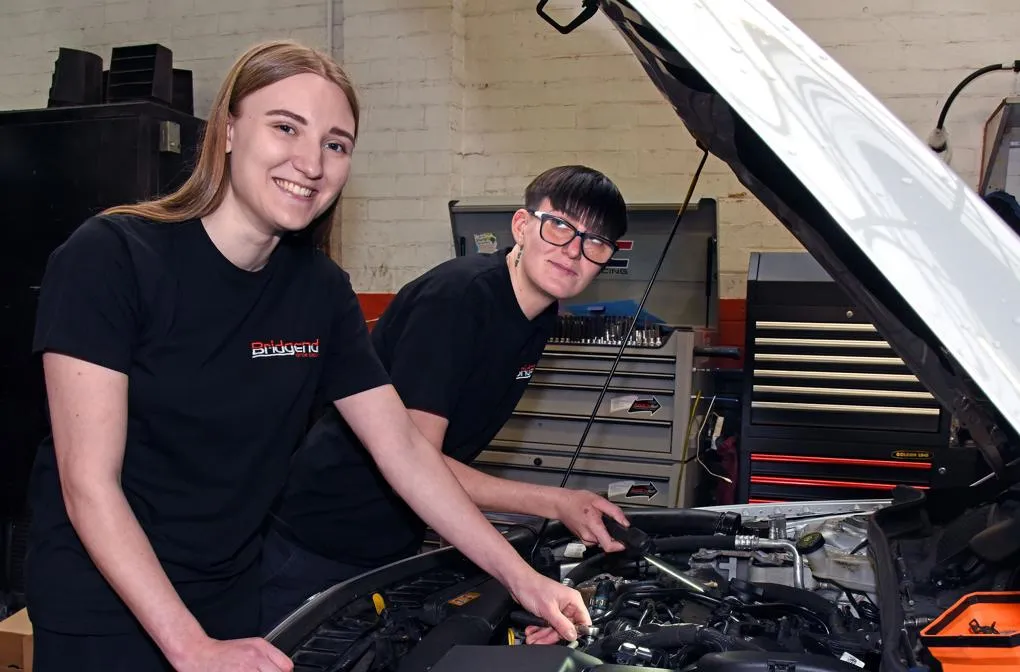 Two women working on a car