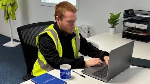 Participant sitting at table typing on a laptop