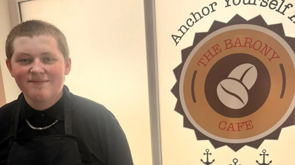 Participant standing in front of café logo reading 'The Barony Cafe'.